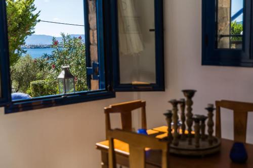 a dining room with a table and chairs and a window at Villa Euphoria Studio in Aegina, A' Marathonas Bay in Aegina Town