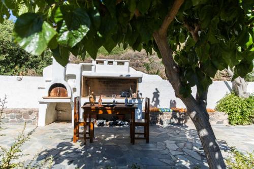 a pizza oven with a table and a table and chairs at Villa Euphoria Studio in Aegina, A' Marathonas Bay in Egina
