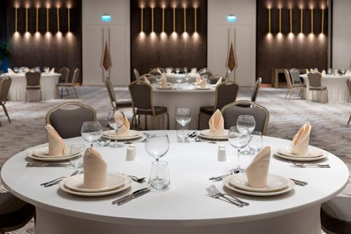 a table with plates and napkins on it in a restaurant at Limak Skopje Luxury Hotel in Skopje
