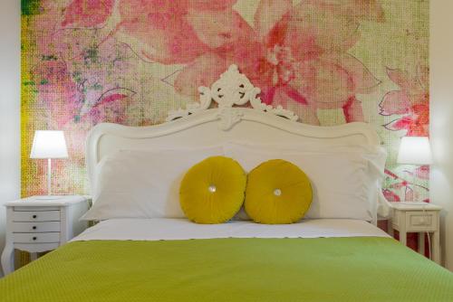a bedroom with a white bed with two yellow pillows at Giardino Giusti House & Court in Verona