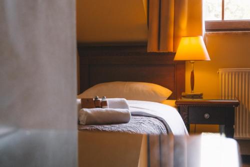 ジェロナ・グラにあるForRest Hotel & Restaurantのベッドとタオル2枚のある寝室