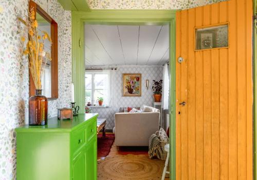 a room with a green cabinet and a living room at Rustik gäststuga med lantlig känsla nära Örebro city in Örebro