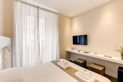 a hotel room with a bed and a tv at ECCE ROMA in Rome