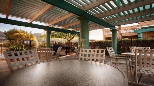 a man sitting on a bench in front of a patio at Sure Stay Plus by Best Western Twentynine Palms Joshua Tree in Twentynine Palms