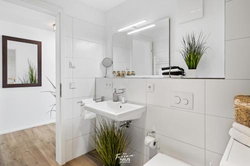 a white bathroom with a sink and a mirror at Port Olpenitz in Olpenitz