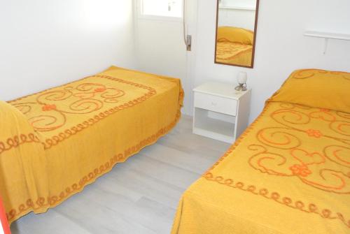 een slaapkamer met 2 bedden en een spiegel bij DUNA 4 in Lignano Sabbiadoro