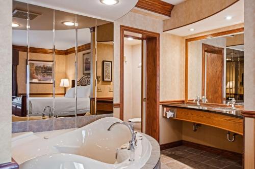 a large bathroom with a tub and a bedroom at Best Western Parkway Inn & Conference Centre in Cornwall