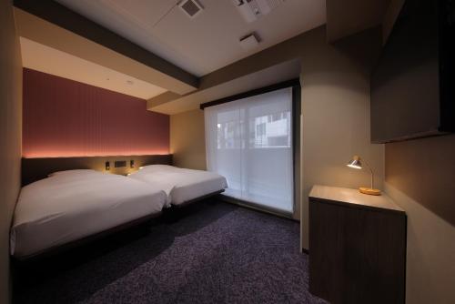 Llit o llits en una habitació de Hotel SUI Kobe Sannomiya by ABEST