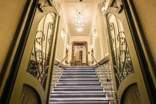 a staircase leading to a building with a chandelier at Liebeskind Boutique Hotel Old Town in Kraków