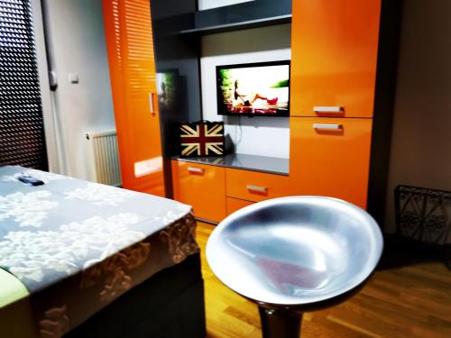 a room with a table and a stool and a tv at Apartment CITY in Doboj