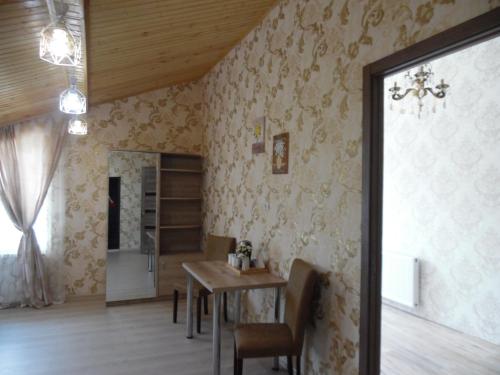 a dining room with a table and chairs in a room at Guest House Tamta in Stepantsminda