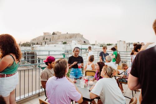 un gruppo di persone seduti intorno a un tavolo sul balcone di Athens Backpackers ad Atene
