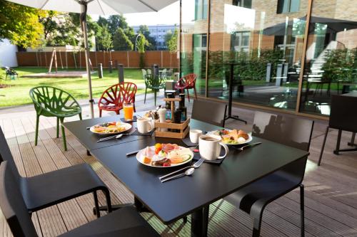 una mesa negra con platos de comida en un patio en aletto Hotel Potsdamer Platz, en Berlín