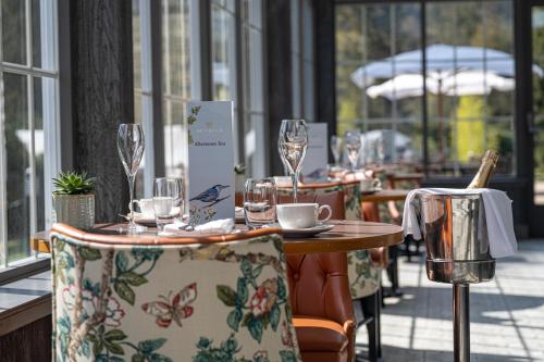 a table in a restaurant with chairs and wine glasses at Dunkeld House Hotel in Dunkeld