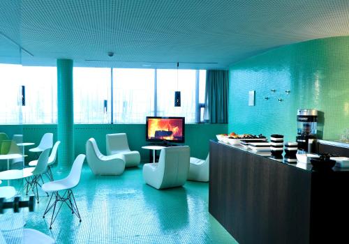 a kitchen with blue walls and white chairs and a counter at LOISIUM Wine & Spa Hotel Langenlois in Langenlois