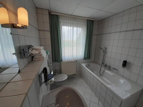 a bathroom with a tub and a toilet and a sink at Edit Pension Rossau in Rossau