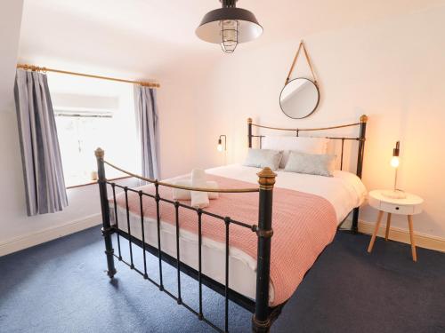 a bedroom with a bed and a mirror at Harbourside in Porthmadog