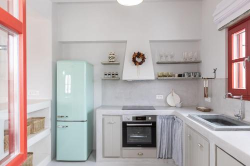a kitchen with a blue refrigerator and a sink at Marathi Mykonos in Klouvas
