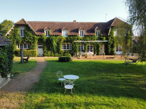 a house with a table and chairs in the yard at Maison Angulus Ridet in Montcresson