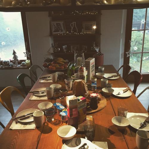 uma longa mesa de madeira com comida em cima em LaMaisonRouge chambre d'hôtes em Cormondreche