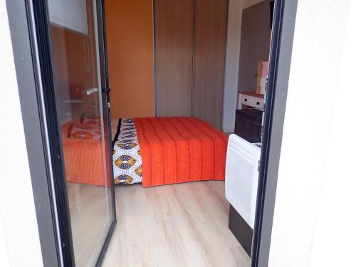 een kleine kamer met een bed met een rode deken bij Proche GR34 , Studio "Estrella" , petit cocon accueillant in Hillion
