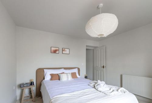 ein Schlafzimmer mit einem großen Bett mit einer großen Leuchte in der Unterkunft Round House Cottage in Castle Cary