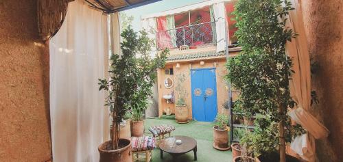 an open balcony with a blue door and potted plants at Be Nomad in Marrakech