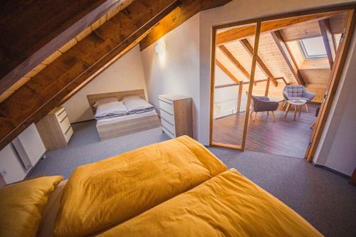 a bedroom with a large yellow bed in a attic at ZORE JASNÁ Apartments in Belá