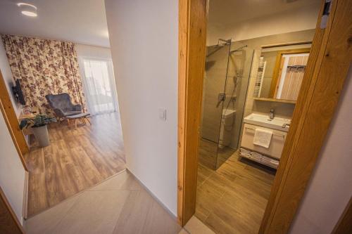 a bathroom with a shower and a sink and a mirror at ZORE JASNÁ Apartments in Demanovska Dolina