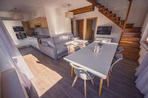 a kitchen and living room with a table and chairs at ZORE JASNÁ Apartments in Demanovska Dolina