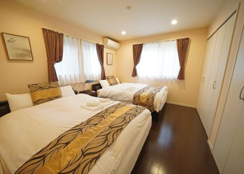 a hotel room with two beds and a window at 浅草ザ アパートメント Asakusa The Apartment in Tokyo