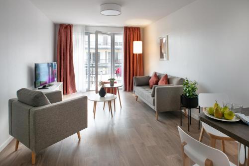 a living room with two couches and a table at DOMITYS LA SALAMANDRE in Vitry-le-François