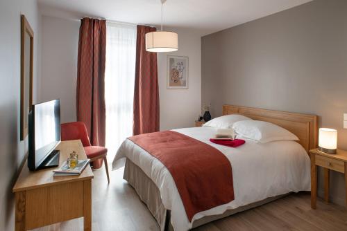 a hotel room with a bed and a television at DOMITYS LA SALAMANDRE in Vitry-le-François