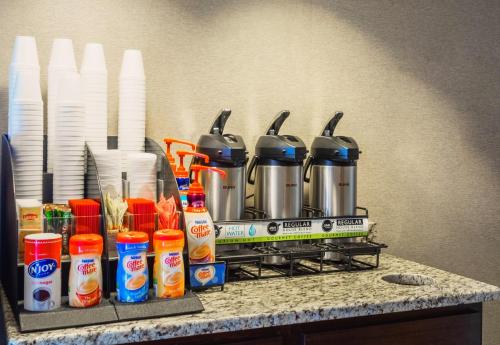 a counter with a coffee maker and condiments at Red Roof Inn PLUS+ South Deerfield - Amherst in South Deerfield