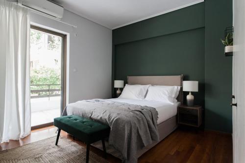 Pleasant 2BR Apartment near HELEXPO by UPSTREET في أثينا: غرفة نوم مع سرير وبجدار لكنة خضراء