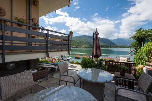 a patio with tables and chairs and a view of a lake at CASA VACANZA IL SORRISO DEL LAGO in Avigliana