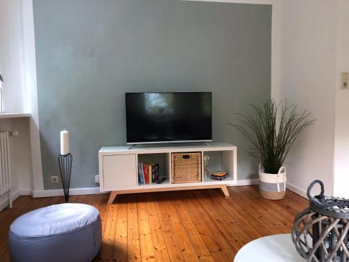 a living room with a flat screen tv on a white entertainment center at Ferienwohnung „Die Koje“ Hohwacht/Ostsee in Hohwacht