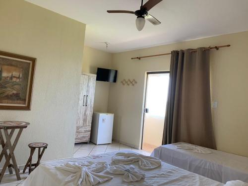 um quarto com 2 camas e uma ventoinha de tecto em Pousada Muzy em Barra de São João