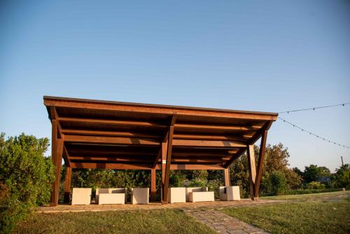 a wooden pavilion with white seating in a park at Trulli Paparale in Alberobello