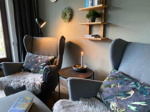 a living room with a couch and a candle on a table at Ferienwohnung Gipfelglück zwischen Bikepark & Skipiste in Winterberg