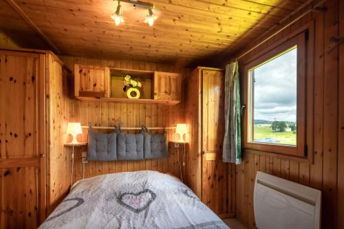 a bedroom with a bed in a wooden cabin at L étincelle du Manon in Lajoux