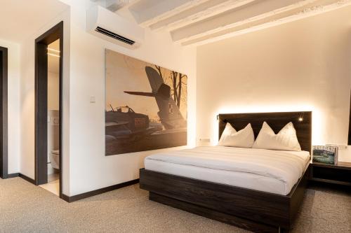 a bedroom with a bed and a painting on the wall at Hotel Spitzerberg by b-smart 