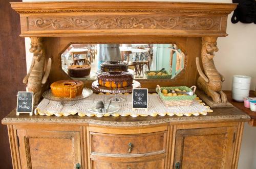 a display of cakes and other desserts on a cabinet at Pousada Estrelas no Mar Florianópolis in Florianópolis