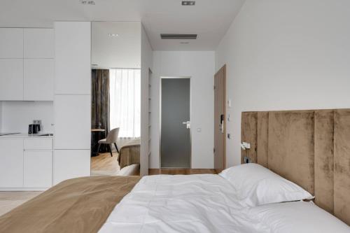 a bedroom with a large bed with white walls at BASIS APARTMENTS - Adults Only in Kyiv