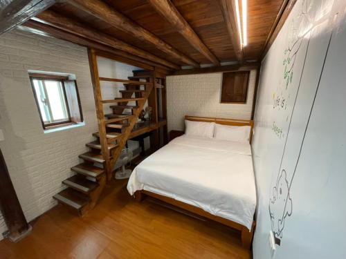 um pequeno quarto com uma cama e uma escada em Chinbe D.S House 2 em Beigan