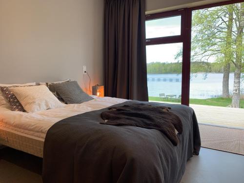 a bedroom with a large bed with a large window at Åkulla Outdoor Resort in Rolfstorp