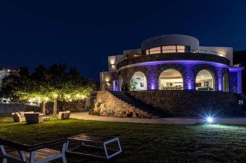 a building with purple lights on it at night at Kouros Exclusive Hotel & Suites - Adults Only in Faliraki