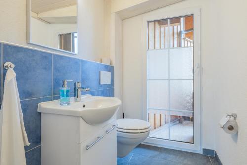 a bathroom with a white sink and a toilet at Hasel in Interlaken