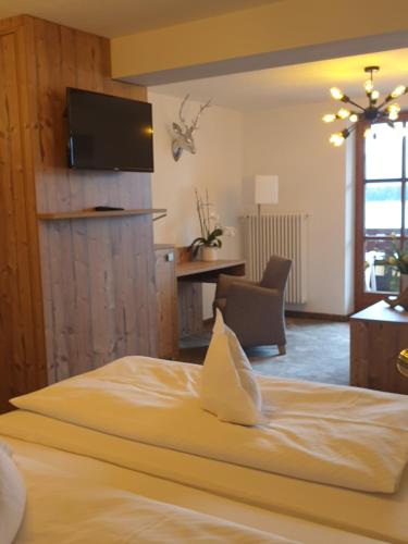 a bedroom with a bed and a desk and a television at Hotel Geiger in Füssen