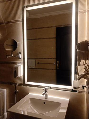 a bathroom with a sink and a large mirror at Sheraton Ocean 704 - Without Pool access in Cairo